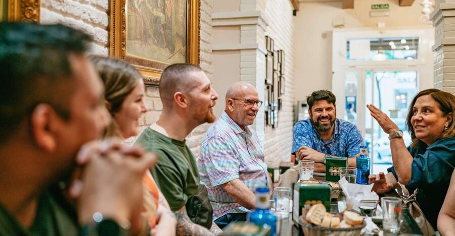 Madrid: Food & Wine Tour with 10 Tapas & 4 Drinks Included - Stop one: market cooking and a first taste of Madrid